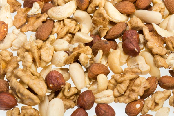 Bakgrund av blandade nötter - hasselnötter, valnötter, cashewnötter och pinjenötter — Stockfoto