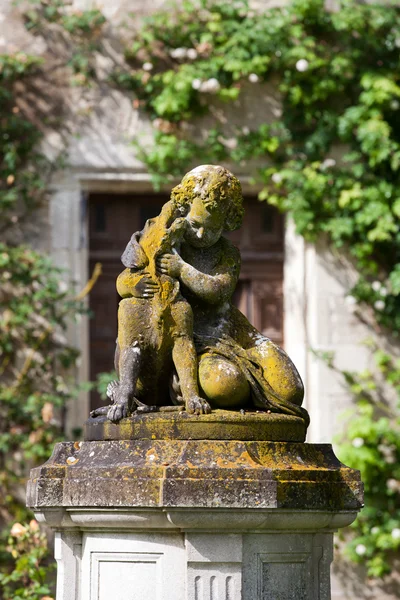 Het beeld van het kind met de hond in de tuin van het kasteel in montresor — Stockfoto