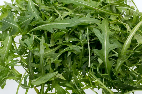 Cumulo di foglie di ruccola isolato su sfondo bianco — Foto Stock