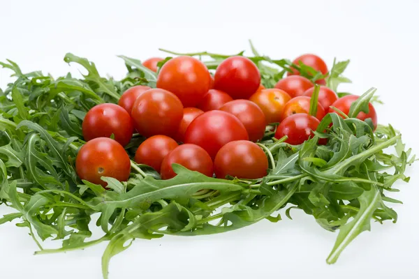 Heap of ruccola leaves and cherry tomatoes — Stock Photo, Image