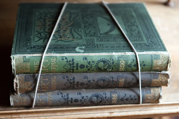 Винтажные книги в разных оттенках зеленого в книжном шкафу — стоковое фото