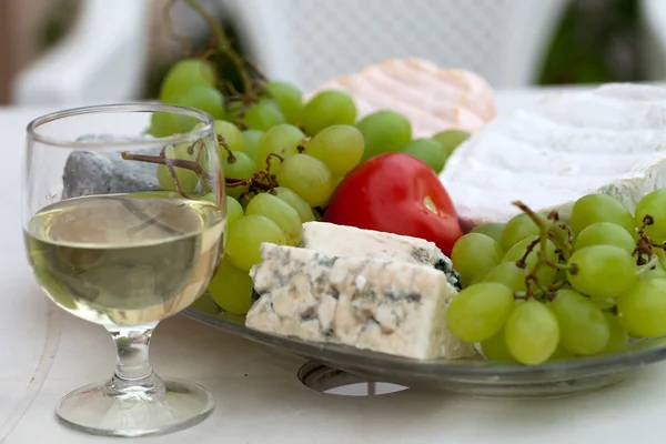 Різні види сиру, винограду і келиха білого вина — стокове фото