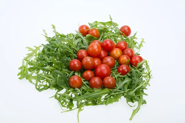 Heap of ruccola leaves and cherry tomatoes — Stock Photo, Image