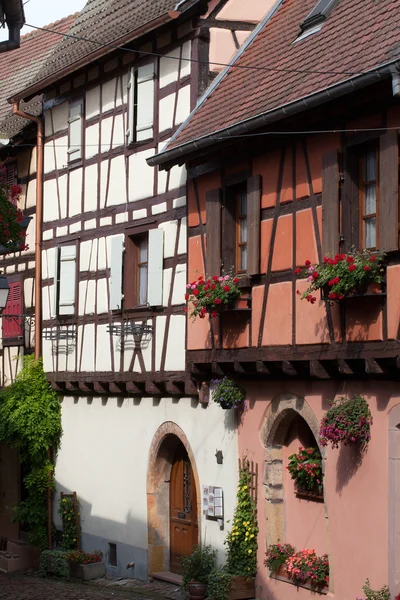 Strada con case medievali a graticcio nel villaggio di Eguisheim lungo la famosa strada del vino in Alsazia, Francia — Foto Stock