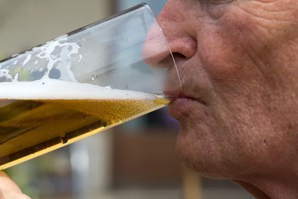 Homem maduro bebe cerveja. Melhor é o primeiro calado — Fotografia de Stock