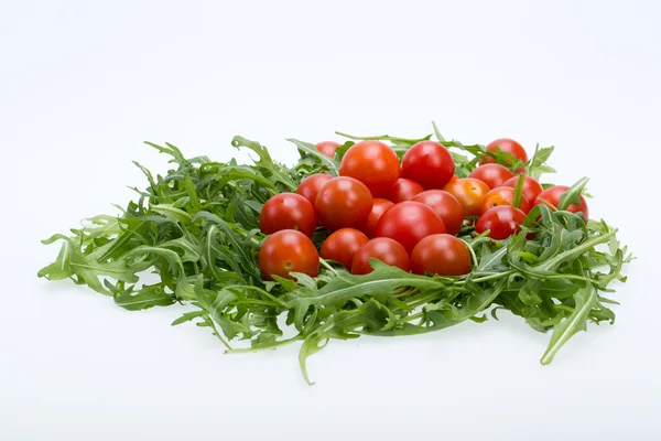 Heap of ruccola leaves and cherry tomatoes — Stock Photo, Image