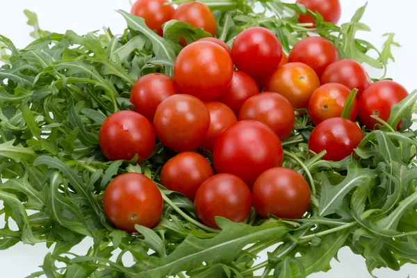 Heap of ruccola leaves and cherry tomatoes — Stock Photo, Image