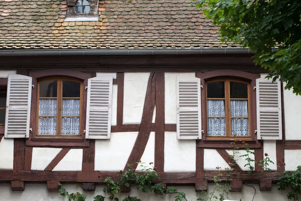 Calle con casas medievales de entramado de madera en el pueblo de Eguisheim a lo largo de la famosa ruta del vino en Alsacia, Francia —  Fotos de Stock
