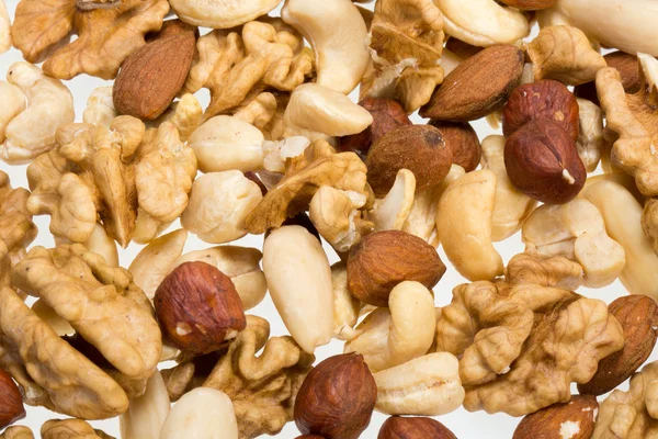 Bakgrund av blandade nötter - hasselnötter, valnötter, cashewnötter och pinjenötter — Stockfoto