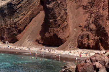 Santorini, Yunanistan - 01 Temmuz 2021: Santorini adasının güney kıyısındaki ünlü Kızıl Kumsal, Kiklad, Ege Denizi.