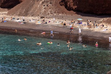 Santorini, Yunanistan - 01 Temmuz 2021: Santorini adasının güney kıyısındaki ünlü Kızıl Kumsal, Kiklad, Ege Denizi.