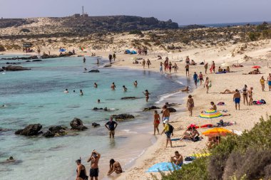 Elafonisi, Girit, Yunanistan - 19 Eylül 2021: Girit, Akdeniz 'deki Elafonisi' nin ünlü pembe mercan plajında dinlenen insanlar 