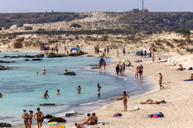 Elafonisi, Girit, Yunanistan - 19 Eylül 2021: Girit, Akdeniz 'deki Elafonisi' nin ünlü pembe mercan plajında dinlenen insanlar 