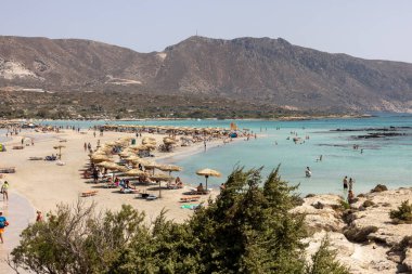 Elafonisi, Girit, Yunanistan - 19 Eylül 2021: Girit, Akdeniz 'deki Elafonisi' nin ünlü pembe mercan plajında dinlenen insanlar 