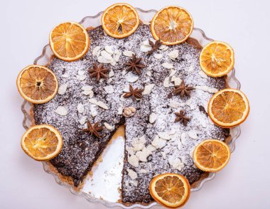 Haşhaş tohumlu tart ve üzerine toz şeker serpiştirilmiş meyve.