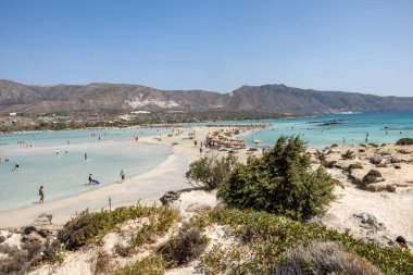 Elafonisi, Girit, Yunanistan - 19 Eylül 2021: Girit, Akdeniz 'deki Elafonisi' nin ünlü pembe mercan plajında dinlenen insanlar 