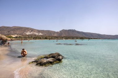 Elafonisi, Girit, Yunanistan - 19 Eylül 2021: Girit, Akdeniz 'deki Elafonisi' nin ünlü pembe mercan plajında dinlenen insanlar 