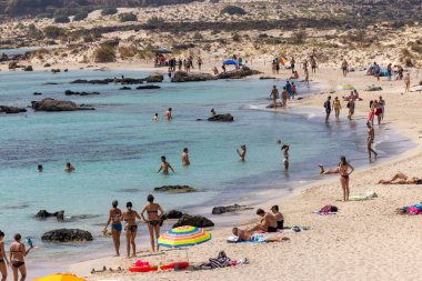 Elafonisi, Girit, Yunanistan - 19 Eylül 2021: Girit, Akdeniz 'deki Elafonisi' nin ünlü pembe mercan plajında dinlenen insanlar 