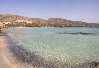 Elafonisi, Girit, Yunanistan - 19 Eylül 2021: Girit, Akdeniz 'deki Elafonisi' nin ünlü pembe mercan plajında dinlenen insanlar 