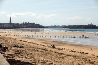 St. Malo, Fransa - 15 Eylül 2018: Saint Malo 'nun pitoresk plajında insanların romantik yürüyüşü. Britanya, Fransa