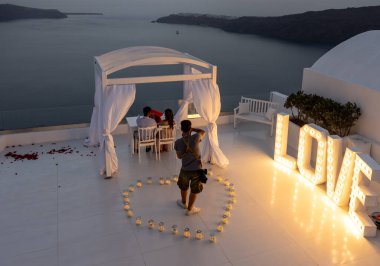 Imerovigli, Santorini, Yunanistan - 1 Temmuz 2021: Santorini Adası 'nda Imergovigli' de romantik bir fotoğraf çekimi sırasında gelin ve damat.