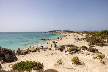 Elafonisi, Girit, Yunanistan - 19 Eylül 2021: Girit, Akdeniz 'deki Elafonisi' nin ünlü pembe mercan plajında dinlenen insanlar 