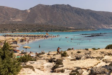 Elafonisi, Girit, Yunanistan - 19 Eylül 2021: Girit, Akdeniz 'deki Elafonisi' nin ünlü pembe mercan plajında dinlenen insanlar 