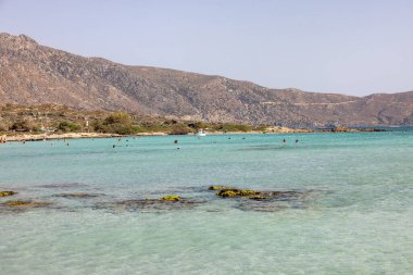 Elafonisi, Girit, Yunanistan - 19 Eylül 2021: Girit, Akdeniz 'deki Elafonisi' nin ünlü pembe mercan plajında dinlenen insanlar 