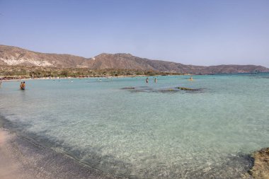 Elafonisi, Girit, Yunanistan - 19 Eylül 2021: Girit, Akdeniz 'deki Elafonisi' nin ünlü pembe mercan plajında dinlenen insanlar 