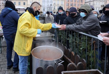 Krakow, Polonya - 19 Aralık 2021: Krakow 'daki ana meydandaki fakir ve evsizler için Noel arifesi. Covid salgınına rağmen Kosciuszko grubu Krakow 'daki açık havada en büyük arifeyi hazırlıyor.