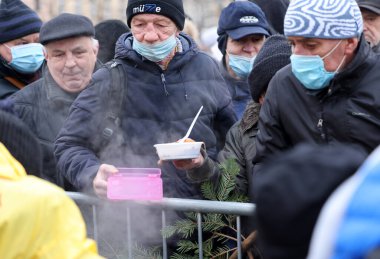 Krakow, Polonya - 19 Aralık 2021: Krakow 'daki ana meydandaki fakir ve evsizler için Noel arifesi. Covid salgınına rağmen Kosciuszko grubu Krakow 'daki açık havada en büyük arifeyi hazırlıyor.