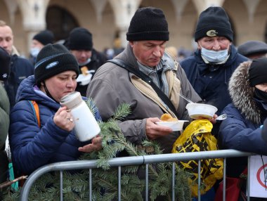 Krakow, Polonya - 19 Aralık 2021: Krakow 'daki ana meydandaki fakir ve evsizler için Noel arifesi. Covid salgınına rağmen Kosciuszko grubu Krakow 'daki açık havada en büyük arifeyi hazırlıyor.