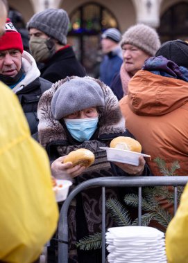Krakow, Polonya - 19 Aralık 2021: Krakow 'daki ana meydandaki fakir ve evsizler için Noel arifesi. Covid salgınına rağmen Kosciuszko grubu Krakow 'daki açık havada en büyük arifeyi hazırlıyor.