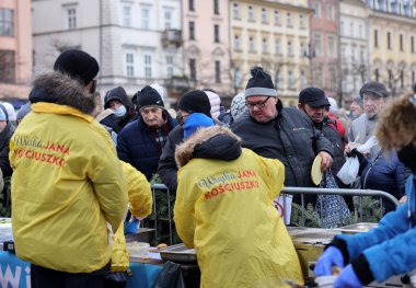 Krakow, Polonya - 19 Aralık 2021: Krakow 'daki ana meydandaki fakir ve evsizler için Noel arifesi. Covid salgınına rağmen Kosciuszko grubu Krakow 'daki açık havada en büyük arifeyi hazırlıyor.