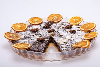 Haşhaş tohumlu tart ve üzerine toz şeker serpiştirilmiş meyve.