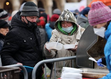 Krakow, Polonya - 19 Aralık 2021: Krakow 'daki ana meydandaki fakir ve evsizler için Noel arifesi. Covid salgınına rağmen Kosciuszko grubu Krakow 'daki açık havada en büyük arifeyi hazırlıyor.