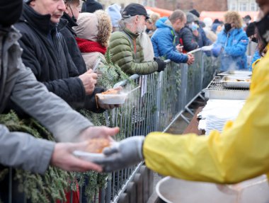 Krakow, Polonya - 19 Aralık 2021: Krakow 'daki ana meydandaki fakir ve evsizler için Noel arifesi. Covid salgınına rağmen Kosciuszko grubu Krakow 'daki açık havada en büyük arifeyi hazırlıyor.
