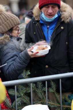 Krakow, Polonya - 19 Aralık 2021: Krakow 'daki ana meydandaki fakir ve evsizler için Noel arifesi. Covid salgınına rağmen Kosciuszko grubu Krakow 'daki açık havada en büyük arifeyi hazırlıyor.