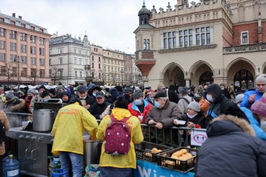 Krakow, Polonya - 19 Aralık 2021: Krakow 'daki ana meydandaki fakir ve evsizler için Noel arifesi. Covid salgınına rağmen Kosciuszko grubu Krakow 'daki açık havada en büyük arifeyi hazırlıyor.