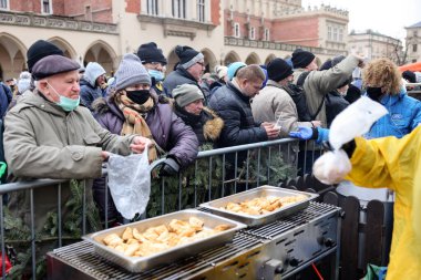 Krakow, Polonya - 19 Aralık 2021: Krakow 'daki ana meydandaki fakir ve evsizler için Noel arifesi. Covid salgınına rağmen Kosciuszko grubu Krakow 'daki açık havada en büyük arifeyi hazırlıyor.