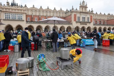 Krakow, Polonya - 19 Aralık 2021: Krakow 'daki ana meydandaki fakir ve evsizler için Noel arifesi. Covid salgınına rağmen Kosciuszko grubu Krakow 'daki açık havada en büyük arifeyi hazırlıyor.