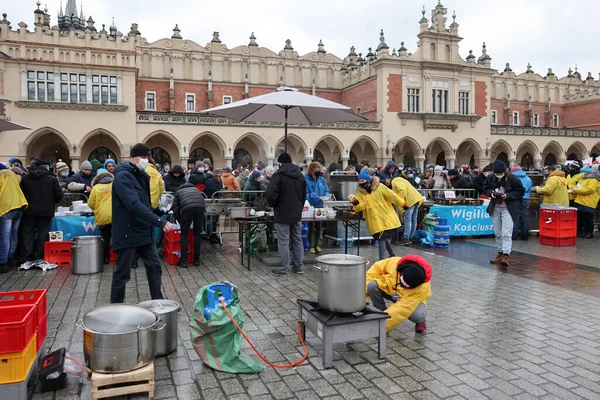 Krakow, Polonya - 19 Aralık 2021: Krakow 'daki ana meydandaki fakir ve evsizler için Noel arifesi. Covid salgınına rağmen Kosciuszko grubu Krakow 'daki açık havada en büyük arifeyi hazırlıyor.