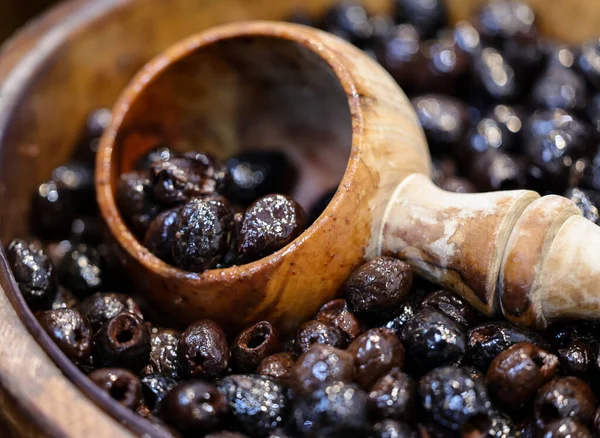 Eski ahşap bir kasede siyah zeytin 
