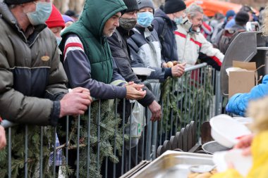Krakow, Polonya - 19 Aralık 2021: Krakow 'daki ana meydandaki fakir ve evsizler için Noel arifesi. Covid salgınına rağmen Kosciuszko grubu Krakow 'daki açık havada en büyük arifeyi hazırlıyor.