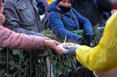 Krakow, Polonya - 19 Aralık 2021: Krakow 'daki ana meydandaki fakir ve evsizler için Noel arifesi. Covid salgınına rağmen Kosciuszko grubu Krakow 'daki açık havada en büyük arifeyi hazırlıyor.