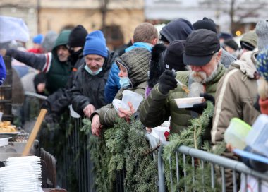 Krakow, Polonya - 19 Aralık 2021: Krakow 'daki ana meydandaki fakir ve evsizler için Noel arifesi. Covid salgınına rağmen Kosciuszko grubu Krakow 'daki açık havada en büyük arifeyi hazırlıyor.
