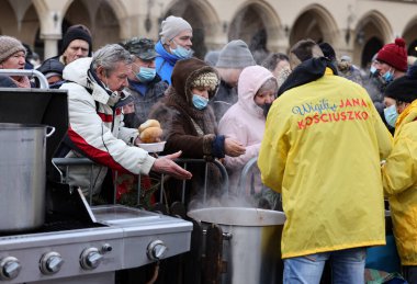 Krakow, Polonya - 19 Aralık 2021: Krakow 'daki ana meydandaki fakir ve evsizler için Noel arifesi. Covid salgınına rağmen Kosciuszko grubu Krakow 'daki açık havada en büyük arifeyi hazırlıyor.