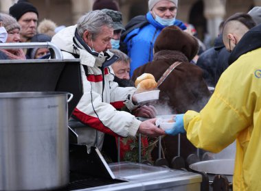 Krakow, Polonya - 19 Aralık 2021: Krakow 'daki ana meydandaki fakir ve evsizler için Noel arifesi. Covid salgınına rağmen Kosciuszko grubu Krakow 'daki açık havada en büyük arifeyi hazırlıyor.