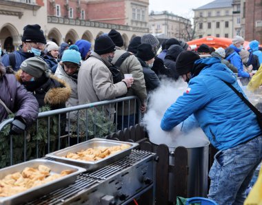Krakow, Polonya - 19 Aralık 2021: Krakow 'daki ana meydandaki fakir ve evsizler için Noel arifesi. Covid salgınına rağmen Kosciuszko grubu Krakow 'daki açık havada en büyük arifeyi hazırlıyor.