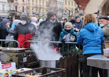 Krakow, Polonya - 19 Aralık 2021: Krakow 'daki ana meydandaki fakir ve evsizler için Noel arifesi. Covid salgınına rağmen Kosciuszko grubu Krakow 'daki açık havada en büyük arifeyi hazırlıyor.